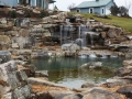 natural swim pond with aquatic plants, boulder walls and flagstone terrace